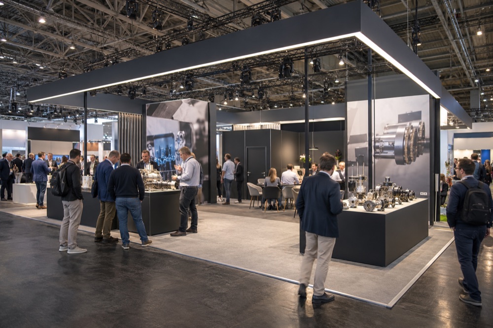 Illustration d’un stand de salon professionnel avec démonstrations, espace de rencontre et structure suspendue